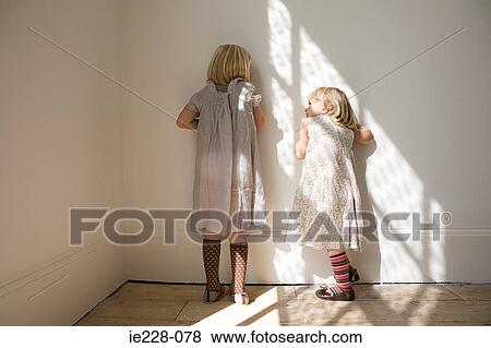 Stock Photo - Girls standing against a wall. Fotosearch