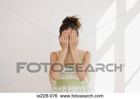 Stock Photograph - Woman covering her face with hands. Fotosearch