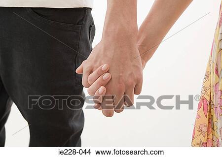 Picture - Young couple holding hands. Fotosearch