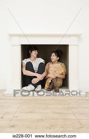 Young couple sitting in a fireplace View Large Photo Image Stock Image - Young couple sitting in a fireplace. Fotosearch