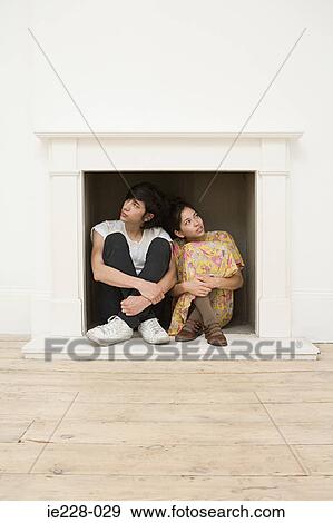 Young couple sitting in a fireplace View Large Photo Image Stock Photo - Young couple sitting in a fireplace. Fotosearch