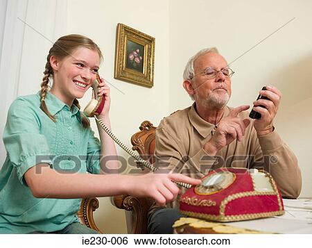 Grandfather and granddaughter using telephones View Large Photo Image Stock Photograph - Grandfather and granddaughter using telephones. Fotosearch