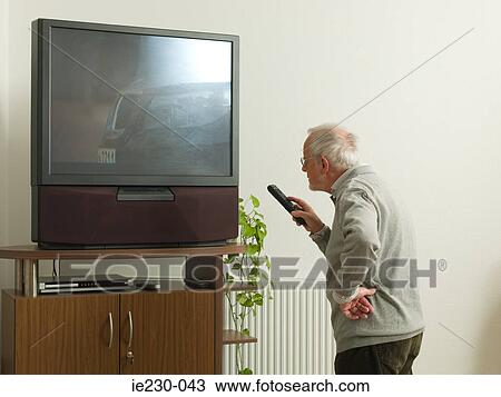 Senior man confused by large television View Large Photo Image Stock Image - Senior man confused by large television. Fotosearch