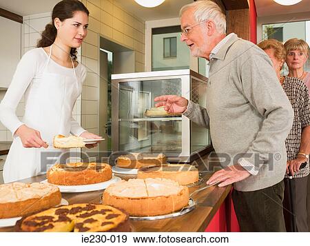 Stock Photo - Seniors queuing for cake. Fotosearch