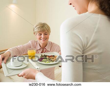 Stock Photograph - Woman getting lunch served in bed. Fotosearch
