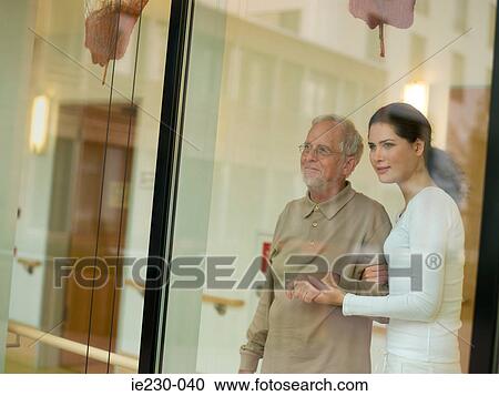 Stock Image - Woman helping a senior man. Fotosearch