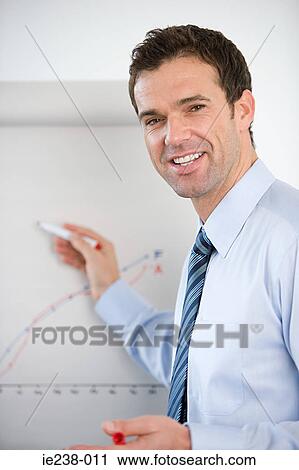 A businessman writing on a flipchart View Large Photo Image Stock Image - A businessman writing on a flipchart. Fotosearch