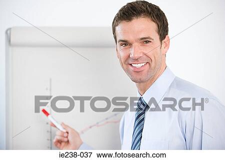 Portrait of a businessman pointing at a flipchart View Large Photo Image Stock Photo - Portrait of a businessman pointing at a flipchart. Fotosearch