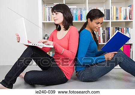 Two women studying back to back View Large Photo Image Stock Photo - Two women studying back to back. Fotosearch