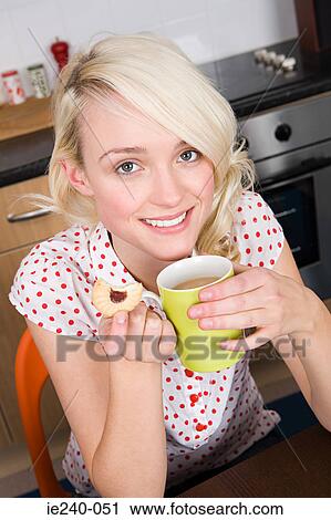 Woman having a cup of tea and a biscuit View Large Photo Image Stock Image - Woman having a cup of tea and a biscuit. Fotosearch
