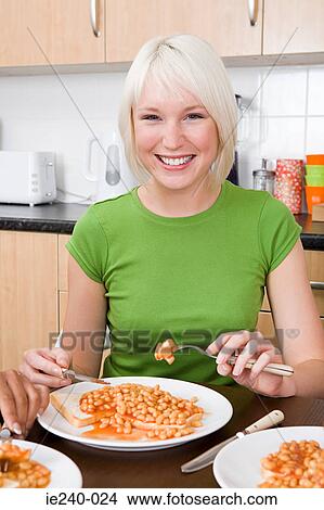 Young woman eating beans on toast View Large Photo Image Picture - Young woman eating beans on toast. Fotosearch