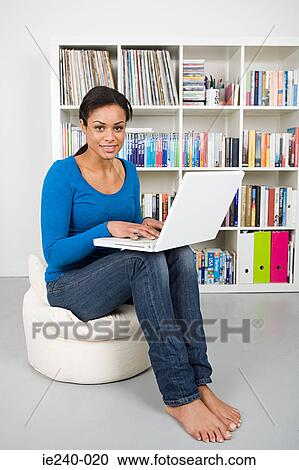 Young woman using a laptop computer View Large Photo Image Stock Image - Young woman using a laptop computer. Fotosearch