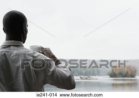 Picture - A businessman holding a cup. Fotosearch