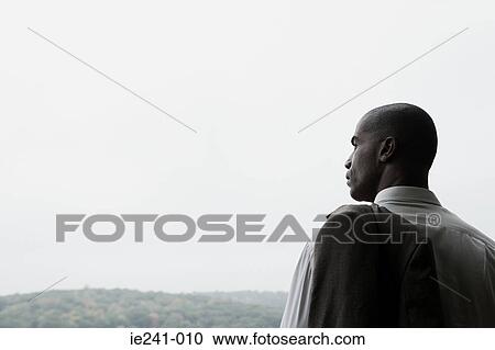 Stock Image - A businessman holding a jacket. Fotosearch