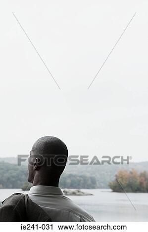 Stock Image - A businessman holding a jacket. Fotosearch