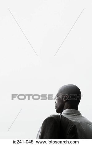 Stock Photo - A businessman holding a jacket. Fotosearch