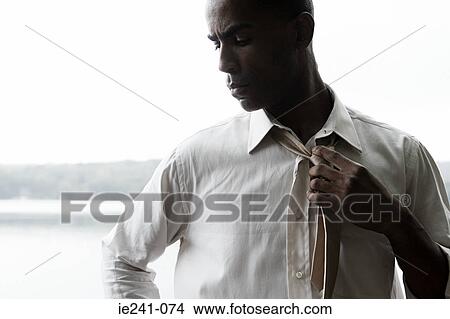 A businessman holding his tie View Large Photo Image Picture - A businessman holding his tie. Fotosearch