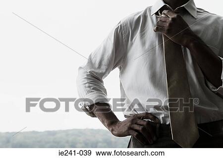 A businessman holding his tie View Large Photo Image Stock Photo - A businessman holding his tie. Fotosearch