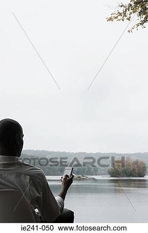 A businessman using a cell phone View Large Photo Image Stock Image - A businessman using a cell phone. Fotosearch