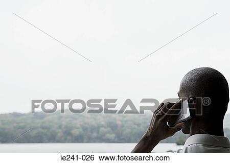 Stock Photograph - A businessman using a cell phone. Fotosearch