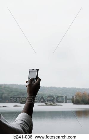 Stock Photograph - A businessman using a cell phone. Fotosearch
