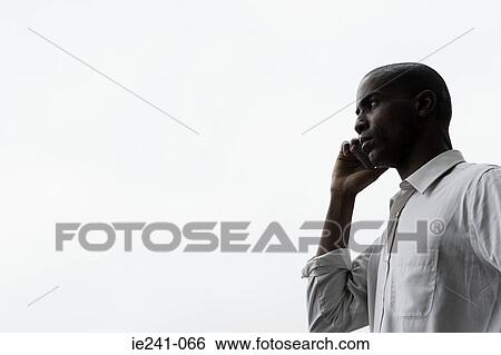 Stock Photograph - A businessman using a cell phone. Fotosearch