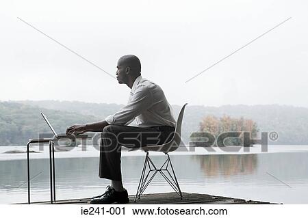 A businessman using a laptop View Large Photo Image Stock Image - A businessman using a laptop. Fotosearch