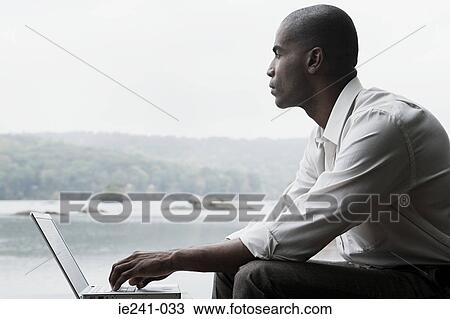 Stock Image - A businessman using a laptop. Fotosearch