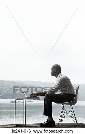 A businessman using a laptop View Large Photo Image Stock Photograph - A businessman using a laptop. Fotosearch