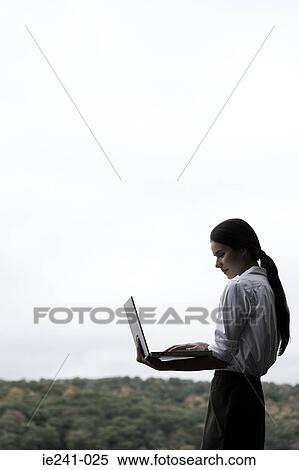 Stock Photography - A businesswoman holding a laptop. Fotosearch