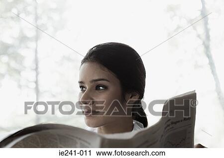 A businesswoman holding a newspaper View Large Photo Image Stock Image - A businesswoman holding a newspaper. Fotosearch