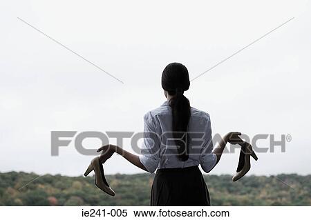 A businesswoman holding high heeled shoes View Large Photo Image Stock Photography - A businesswoman holding high heeled shoes. Fotosearch