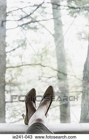 Stock Image - A businesswoman resting her feet. Fotosearch