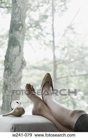Stock Photo - A businesswoman resting her feet. Fotosearch