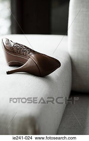 Picture - A high heeled shoe on a sofa. Fotosearch