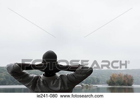 Stock Image - A man with his hands behind his head. Fotosearch