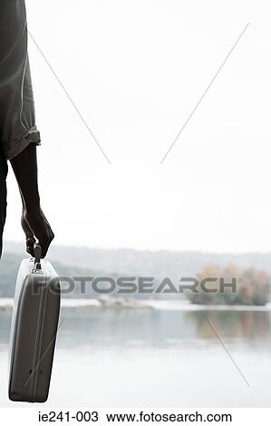 Stock Image - A person holding a briefcase. Fotosearch