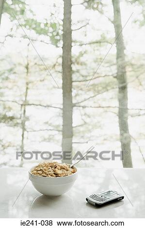 Stock Photo - Bowl of cereal and handheld computer. Fotosearch