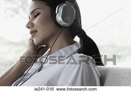 Businesswoman listening to music View Large Photo Image Stock Photograph - Businesswoman listening to music. Fotosearch