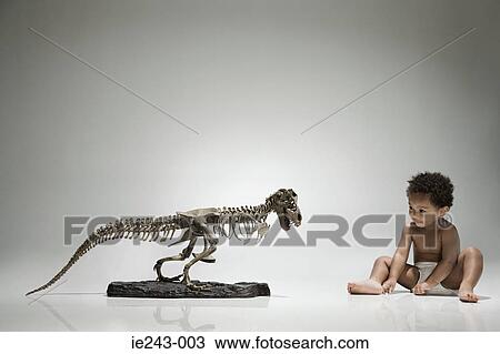 Stock Image - Boy and a dinosaur skeleton. Fotosearch