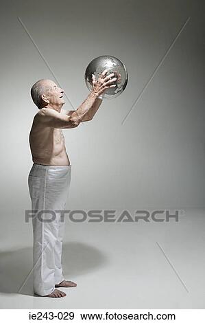 Stock Photo - Senior man holding a globe. Fotosearch