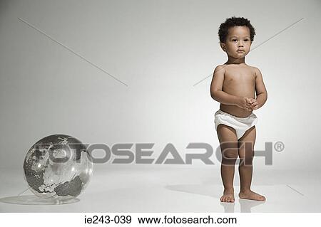 Toddler standing near a globe View Large Photo Image Stock Photo - Toddler standing near a globe. Fotosearch