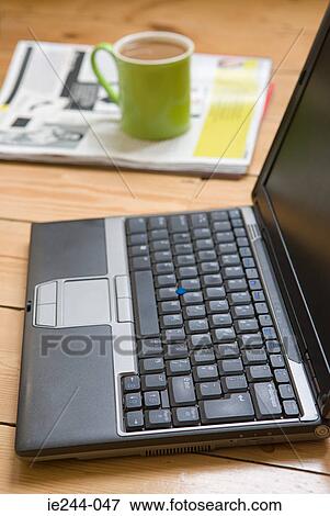 A laptop a cup and a newspaper View Large Photo Image Stock Photo - A laptop a cup and a newspaper. Fotosearch