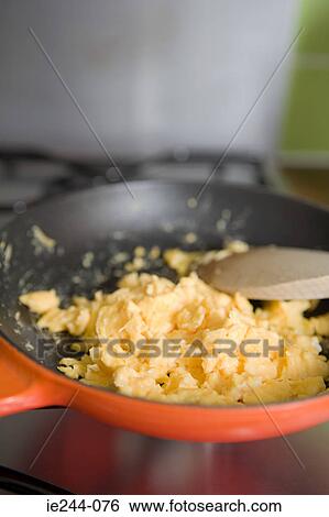 Stock Photograph - Scrambled eggs in a frying pan. Fotosearch