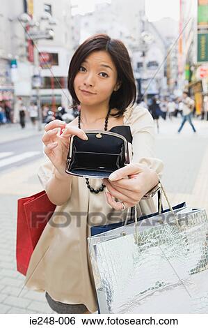 Stock Photograph - A woman showing her empty purse . Fotosearch
