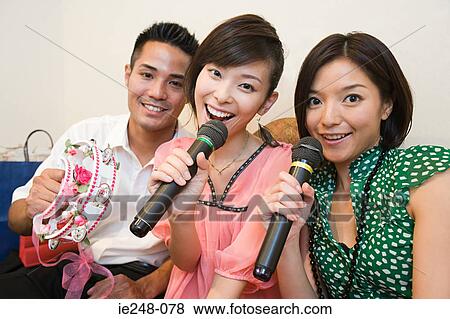 Friends singing karaoke View Large Photo Image Stock Photo - Friends singing karaoke. Fotosearch