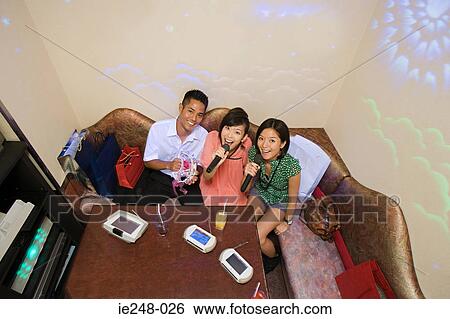 Friends singing karaoke View Large Photo Image Stock Photograph - Friends singing karaoke. Fotosearch