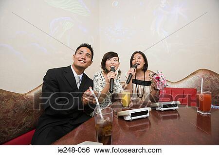 Friends singing karaoke View Large Photo Image Stock Photograph - Friends singing karaoke. Fotosearch