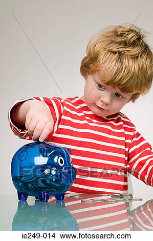 Boy putting money in piggy bank View Large Photo Image Picture - Boy putting money in piggy bank. Fotosearch