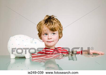 Boy with a piggy bank View Large Photo Image Stock Photo - Boy with a piggy bank. Fotosearch